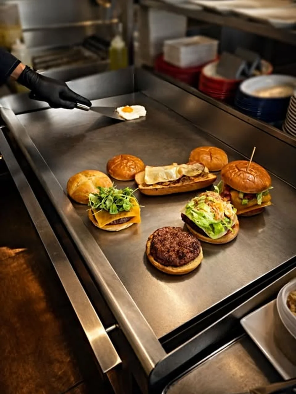 Hamburguesas preparándose en la plancha de Roto's Barcelona